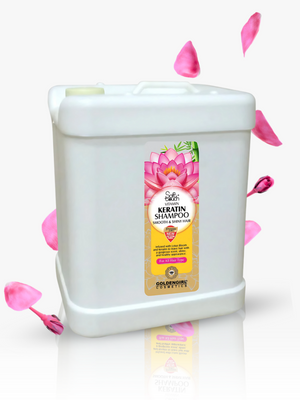White shampoo container with a pink flower design on the label, surrounded by pink petals on a white background.